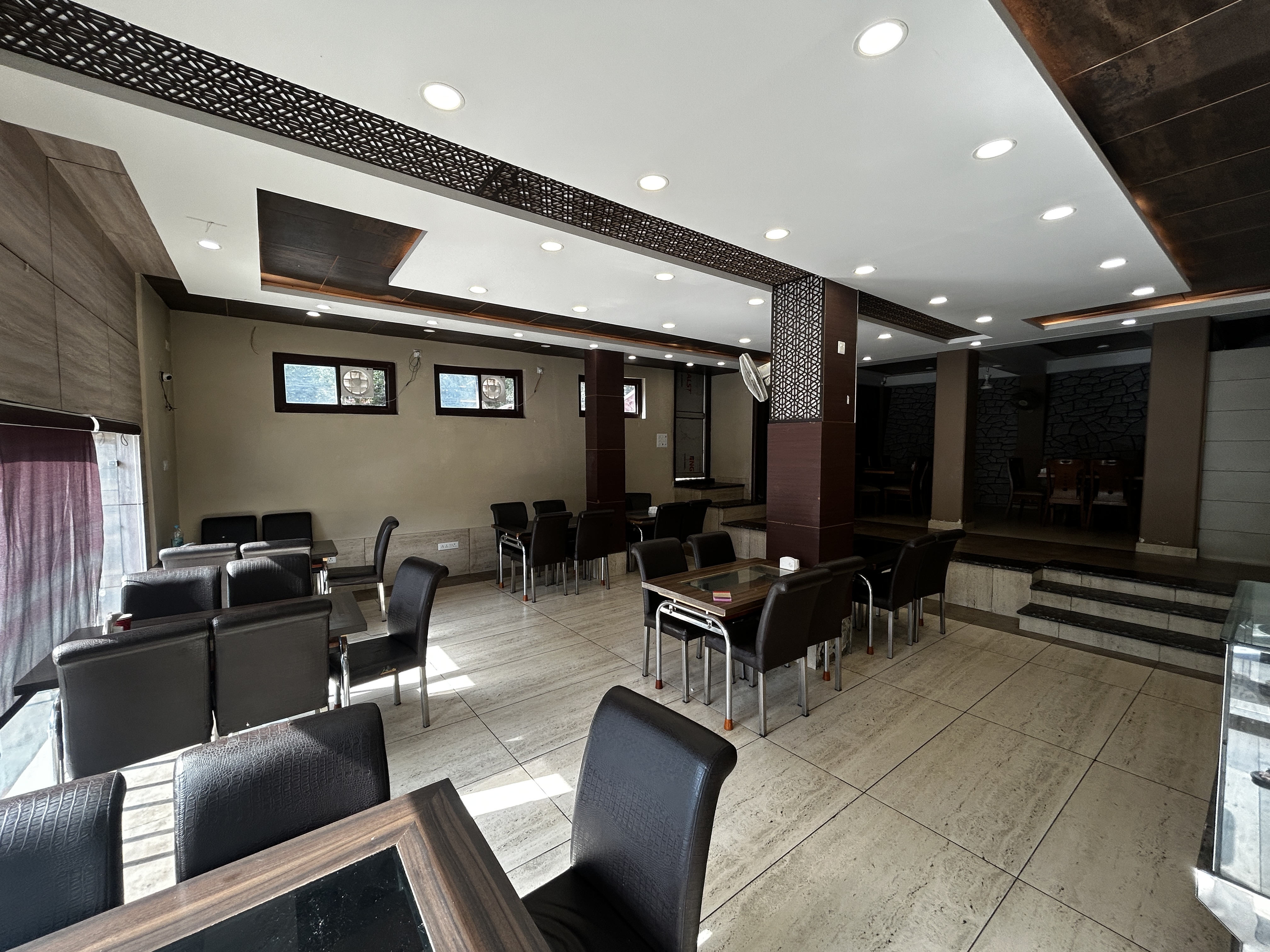 Lower floor dining area at Sunset Boulevard Restaurant - well-lit room with wooden furniture