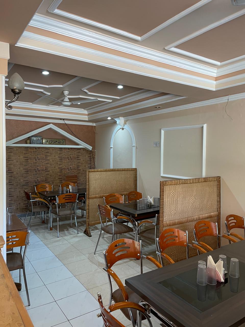 Indoor dining room at Sunset Boulevard Restaurant - wicker partition screens, wooden chairs, dark tables and coffered ceilings